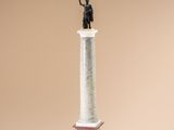statue of a man holding a staff on top of a column