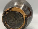 an image of a black vase with a brown label on it