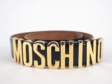 a black and gold belt with the word moschino on it