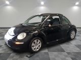 une photo d'une Coccinelle Volkswagen noire garée dans un garage