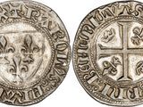 a silver coin with a cross on the front and a shield on the back