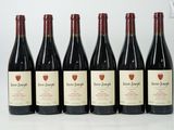 six bottles of wine are lined up on a table