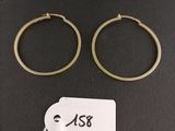 two gold hoop earrings with a price tag on a black background