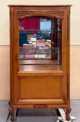 a wooden cabinet with a glass door on the side of it