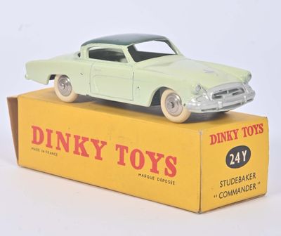 une petite voiture verte posée sur une boîte jaune