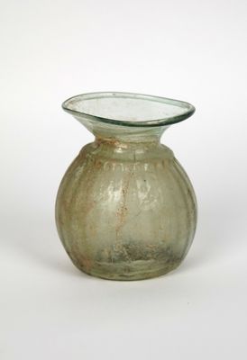 a small glass vase with a green base on a white background