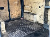 the inside of a van with the door open and the floor covered in dirt