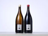 two bottles of wine sitting next to each other on top of a table