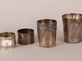 three silver cups and two silver cups on a white surface