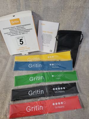 five different colors of wristbands and a black bag
