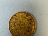 a close up of a gold coin on a white surface