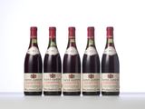 four bottles of wine are lined up on a table
