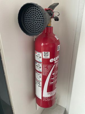 un extincteur rouge fixé au mur