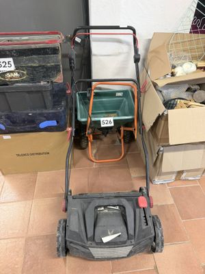 une tondeuse à gazon posée par terre à côté de cartons