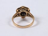 a close up of a gold ring with a black stone