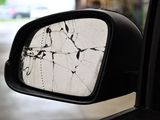 a side view mirror of a car with a cracked window