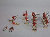 Plusieurs figurines de soldats en uniforme rouge sont disposées sur une surface blanche