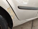 a white car that has been damaged and is sitting on the side of the road