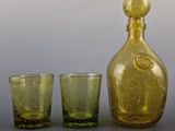 three glasses and a decanter sitting next to each other