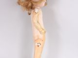 an image of a doll that is standing on a white surface