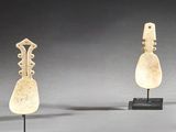 trois œuvres d'art sont exposées sur des socles posés sur une surface grise