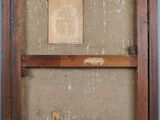 an old wooden frame with a piece of paper hanging on it