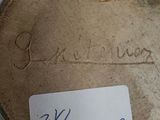 someone is holding a plate with writing on it in front of a wall