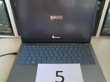 un ordinateur portable posé sur une table sur laquelle figure le chiffre 5