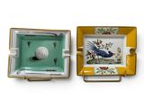 two ashtrays with a bird and a golf ball on them