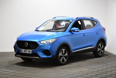 un SUV bleu garé dans une pièce au sol à carreaux