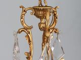 a chandelier that has a candle and a candle holder on it