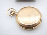 a gold pocket watch sitting on a white surface