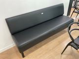 a black bench in a room with chairs and a table