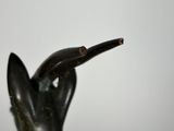 statue of a hand holding a piece of wood sticking out of it ' s mouth