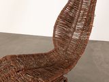 a wicker chair that is sitting on a concrete floor
