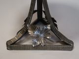 a metal object with a flower on it on a table