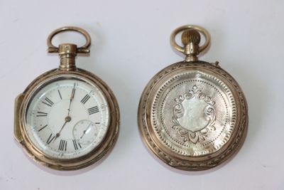 deux vieilles montres de poche posées l'une à côté de l'autre sur une table