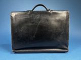 a black briefcase sitting on top of a blue surface