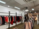 de nombreux vêtements suspendus à un portant dans un magasin