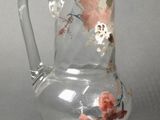 a clear glass pitcher with a floral design on it