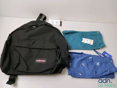 Un sac à dos Eastpak, un pantalon et un t-shirt posés sur une table