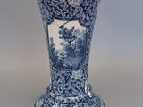 a blue and white vase with a picture of a tree on it