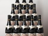 many bottles of wine sitting on a wooden table