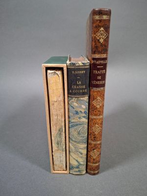 trois livres sont empilés sur une surface grise