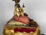 doll sitting on a cushion with a dog on it