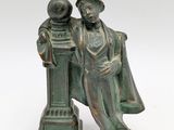 bronze figurine of a man and a woman sitting on a pedestal