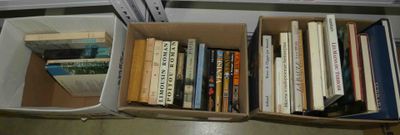 une boîte remplie de livres posée par terre près d'une fenêtre