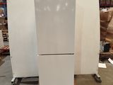 a white refrigerator sitting in a warehouse with pallets
