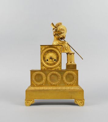 l'image d'une horloge en or posée sur une table