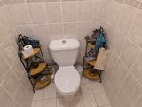 une petite salle de bains équipée de toilettes et d'étagères